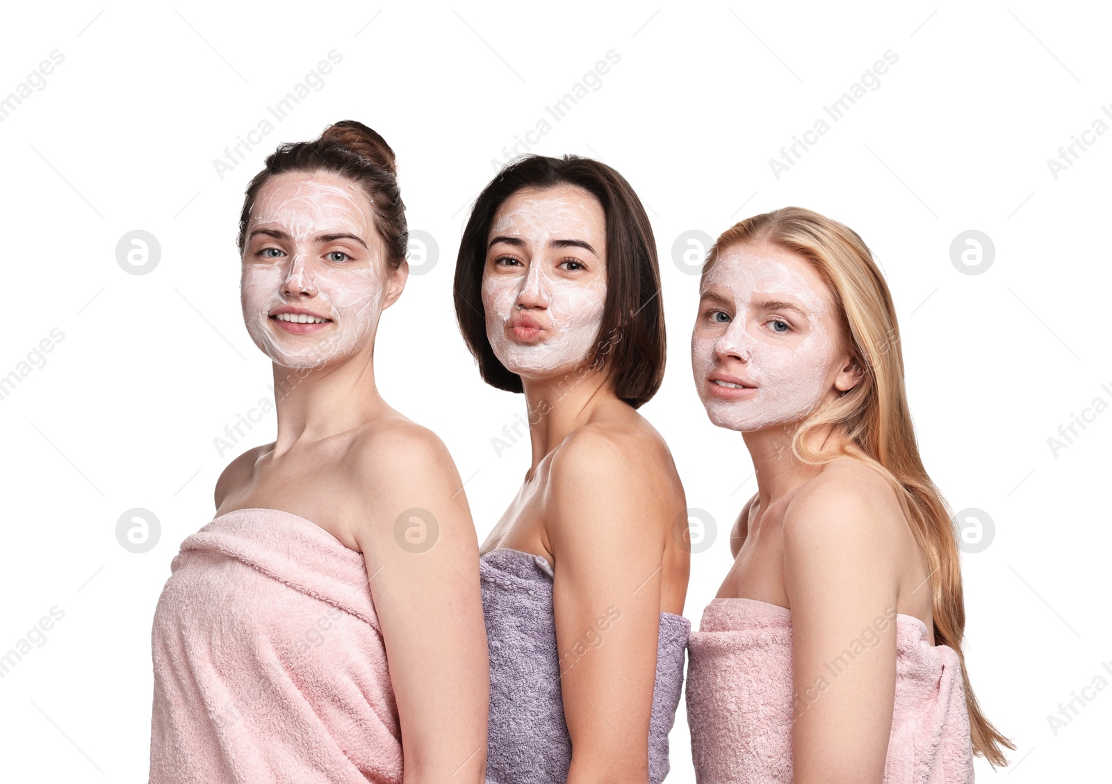 Photo of Spa day. Beautiful women with face masks wrapped in towels on white background