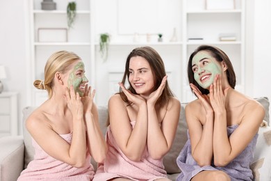 Photo of Spa day. Beautiful women with face masks on sofa indoors