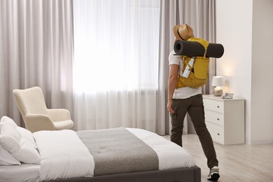 Photo of Traveller with backpack in hotel room, back view