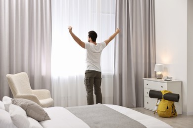 Photo of Traveller standing near window in hotel room