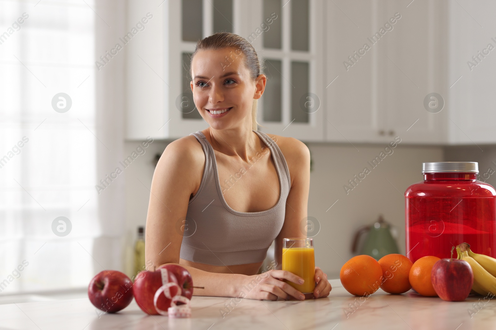 Photo of Weight loss. Happy woman with tasty shake at white marble table in kitchen