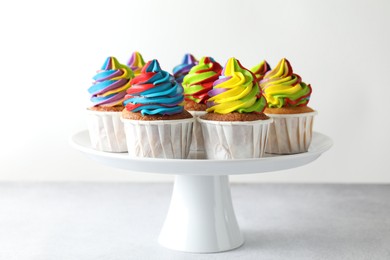 Photo of Tasty cupcakes with colorful cream on white table