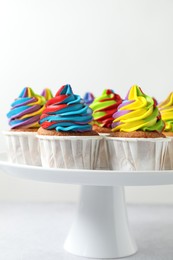 Photo of Tasty cupcakes with colorful cream on white table