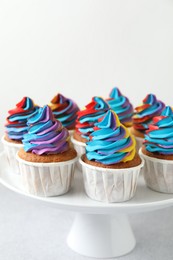 Tasty cupcakes with colorful cream on white table, closeup