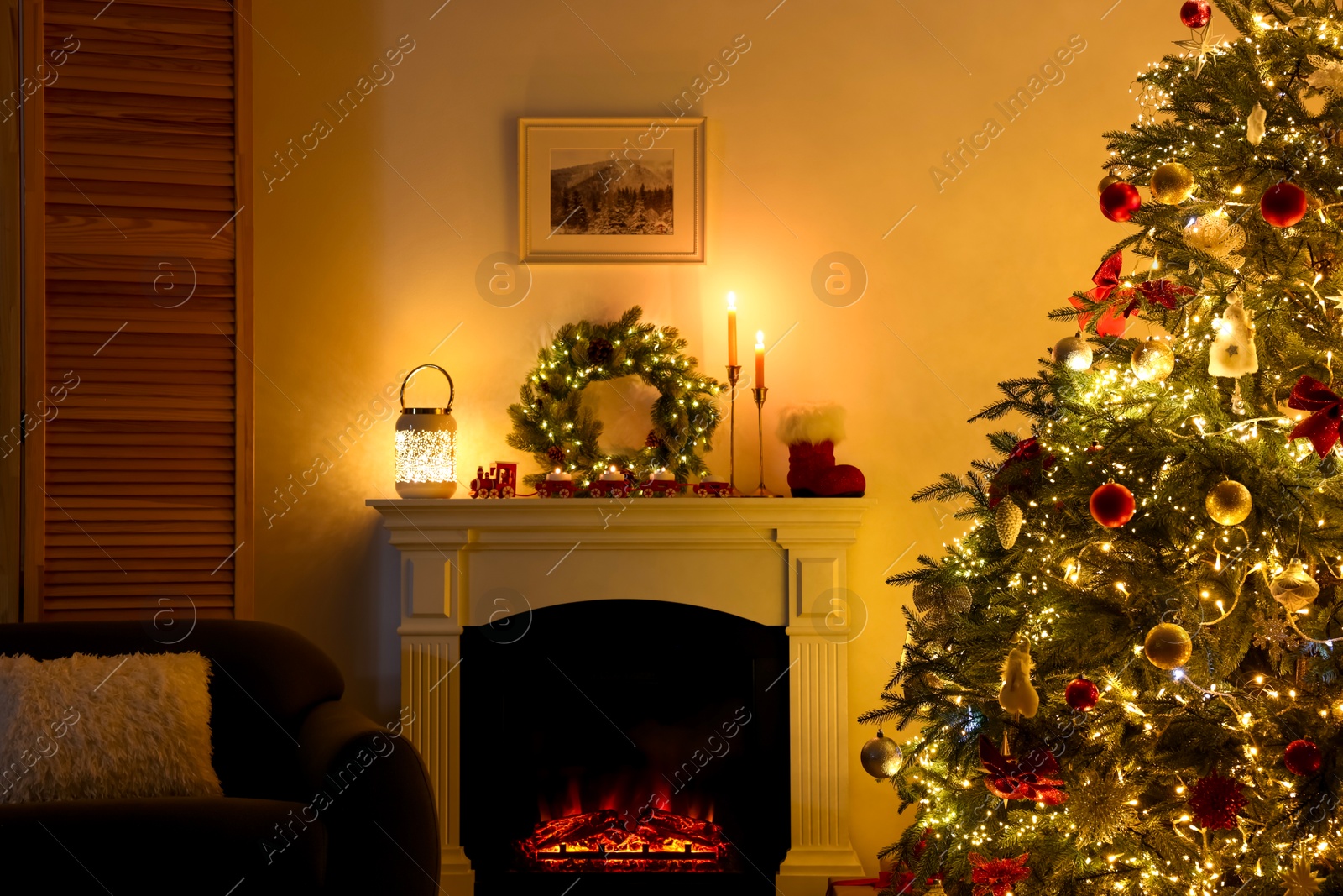 Photo of Decorated Christmas tree near fireplace in room. Festive interior design