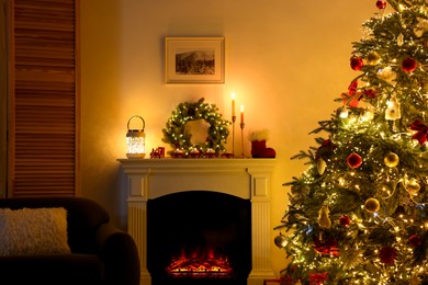 Photo of Decorated Christmas tree near fireplace in room. Festive interior design