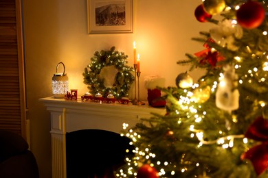 Photo of Decorated fireplace and Christmas tree in room, selective focus. Festive interior design