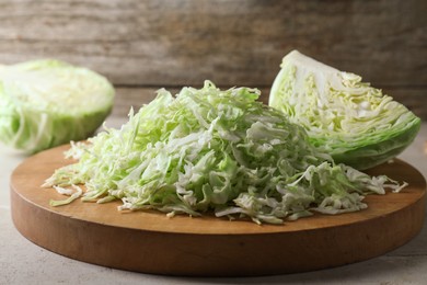 Photo of Fresh shredded cabbage on light table, closeup