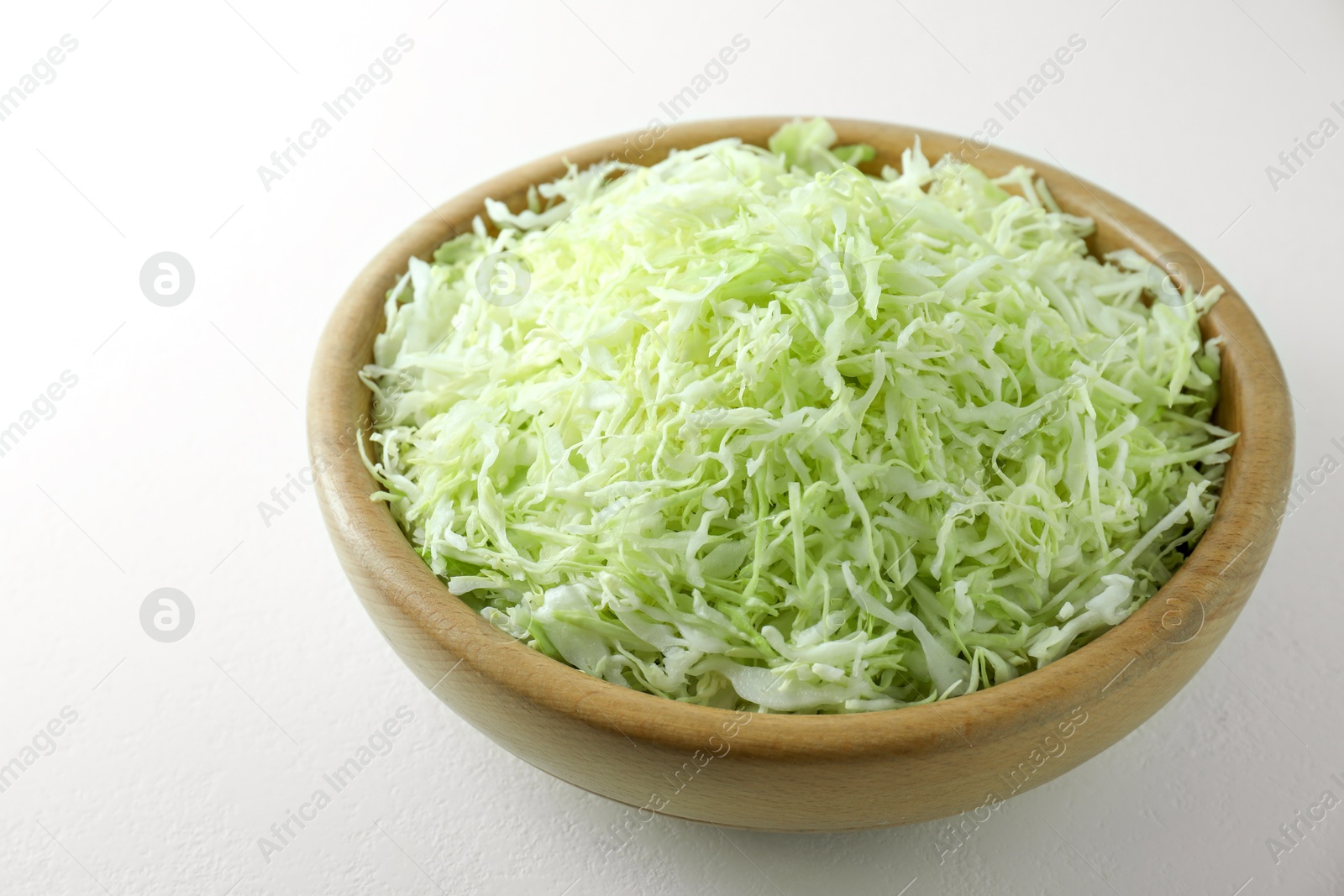 Photo of Fresh shredded cabbage on light table, closeup