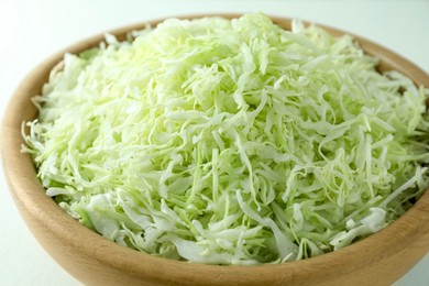 Photo of Fresh shredded cabbage on light table, closeup