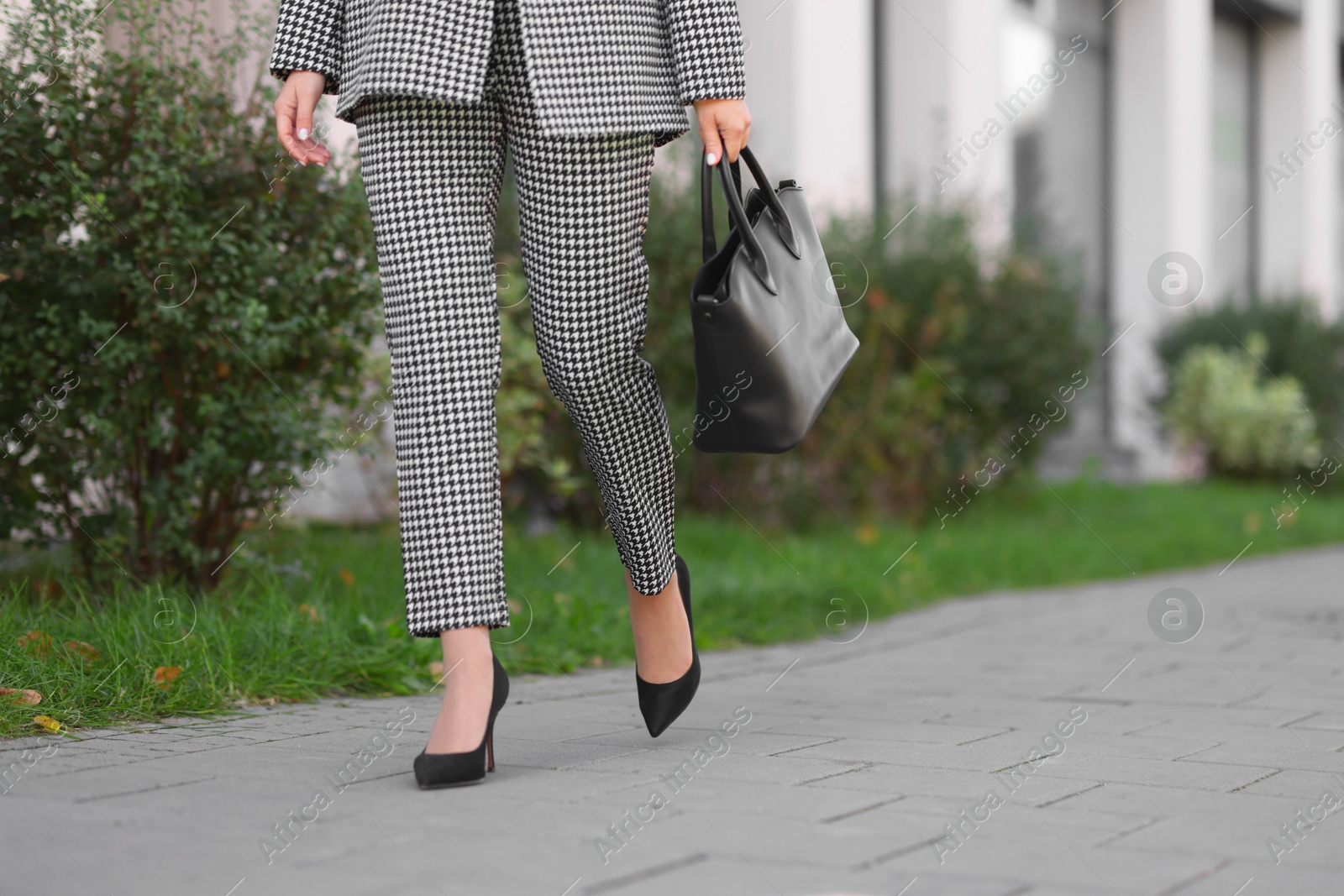 Photo of Businesswoman in stylish suit walking at work outdoors, closeup. Space for text