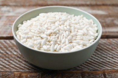 Photo of Puffed rice in bowl on wooden table, closeup