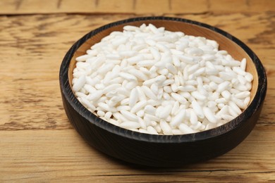 Photo of Puffed rice in bowl on wooden table, closeup