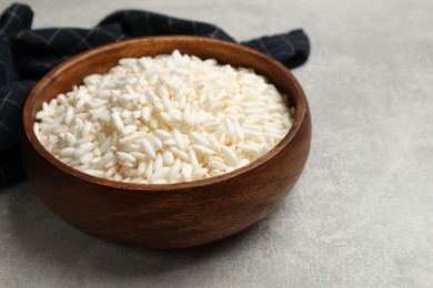 Photo of Puffed rice in bowl on light grey table, closeup