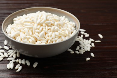 Photo of Puffed rice in bowl on wooden table, closeup