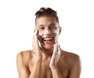 Photo of Smiling man washing his face with cleansing foam on white background