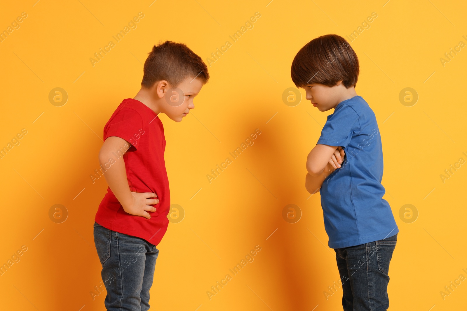 Photo of Angry brothers having argument on orange background