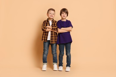 Photo of Full length portrait of cute brothers on beige background