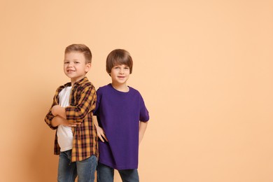 Photo of Portrait of cute brothers on beige background. Space for text