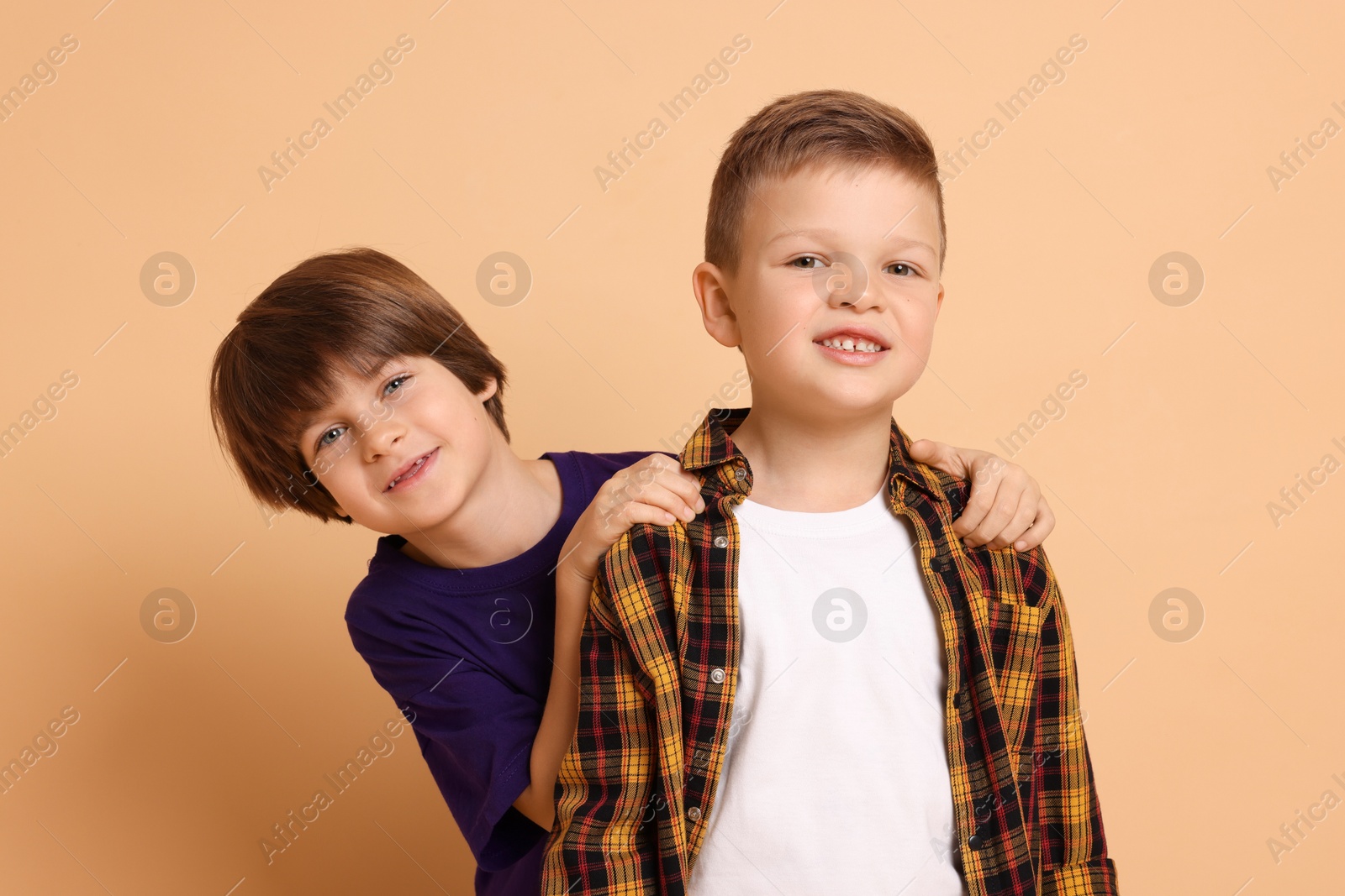 Photo of Portrait of cute brothers on beige background