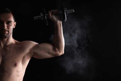 Photo of Man with talcum powder on hand training with barbell against black background. Space for text