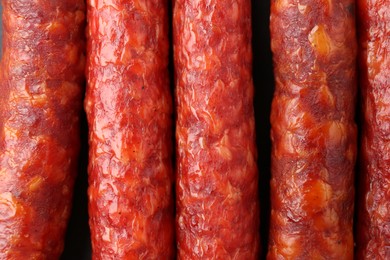 Photo of Many tasty smoked sausages as background, top view