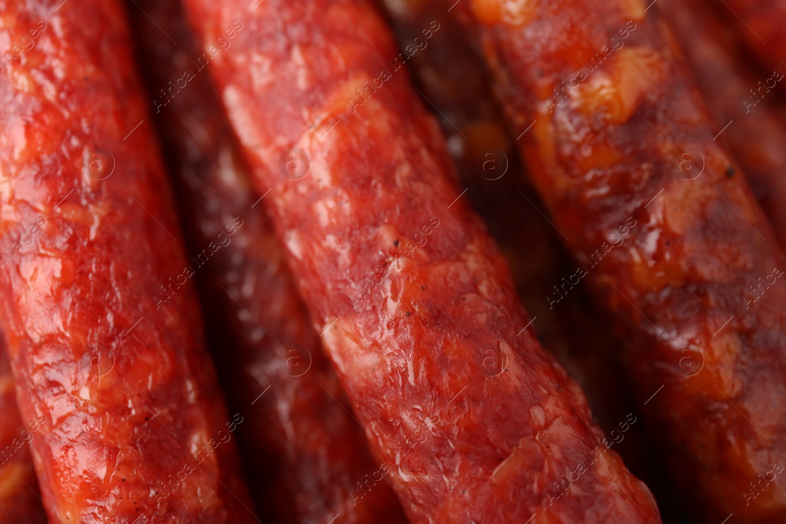 Photo of Different tasty smoked sausages as background, closeup