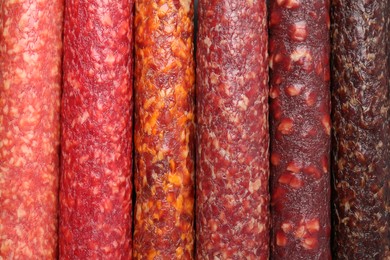 Photo of Different tasty smoked sausages as background, top view