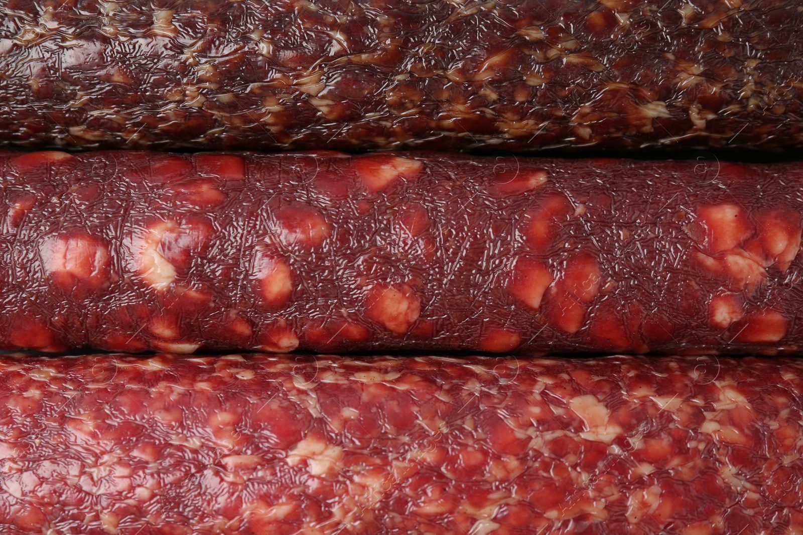 Photo of Different tasty smoked sausages as background, top view