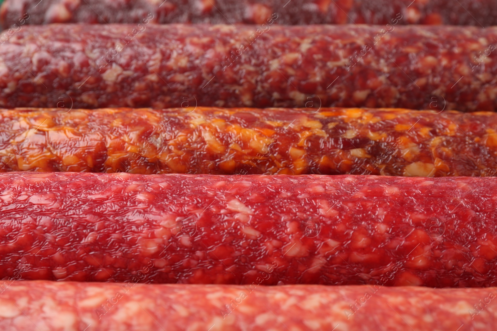 Photo of Different tasty smoked sausages as background, closeup