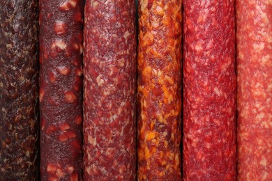 Photo of Different tasty smoked sausages as background, top view