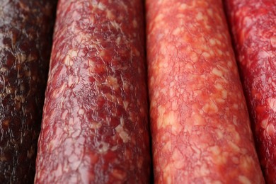 Photo of Different tasty smoked sausages as background, closeup