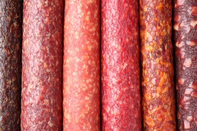 Photo of Different tasty smoked sausages as background, top view