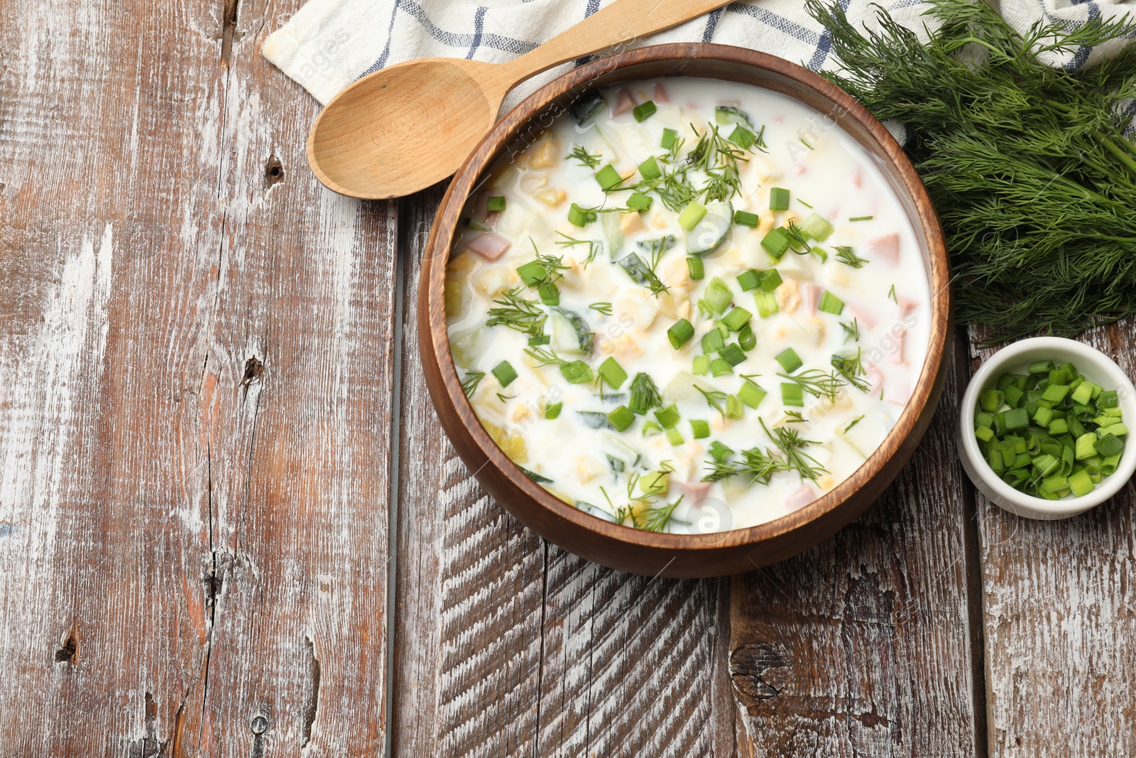 Photo of Delicious okroshka soup with kefir on wooden table, flat lay