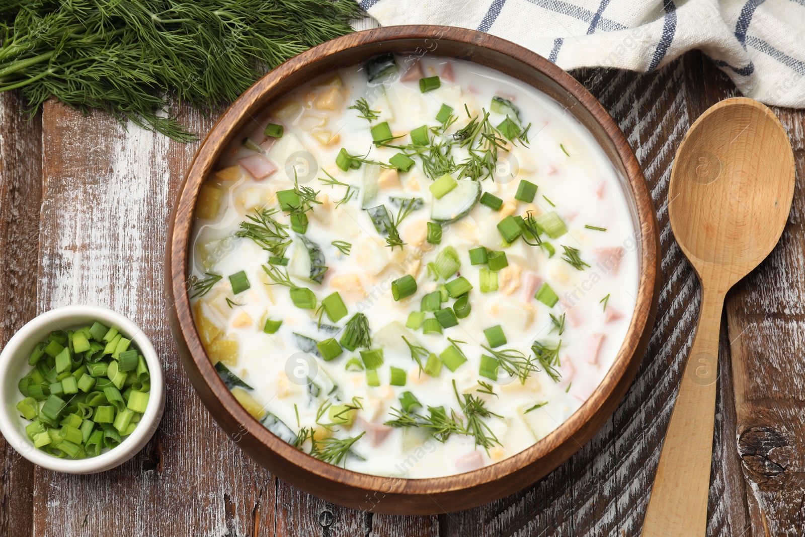 Photo of Delicious okroshka soup with kefir on wooden table, flat lay