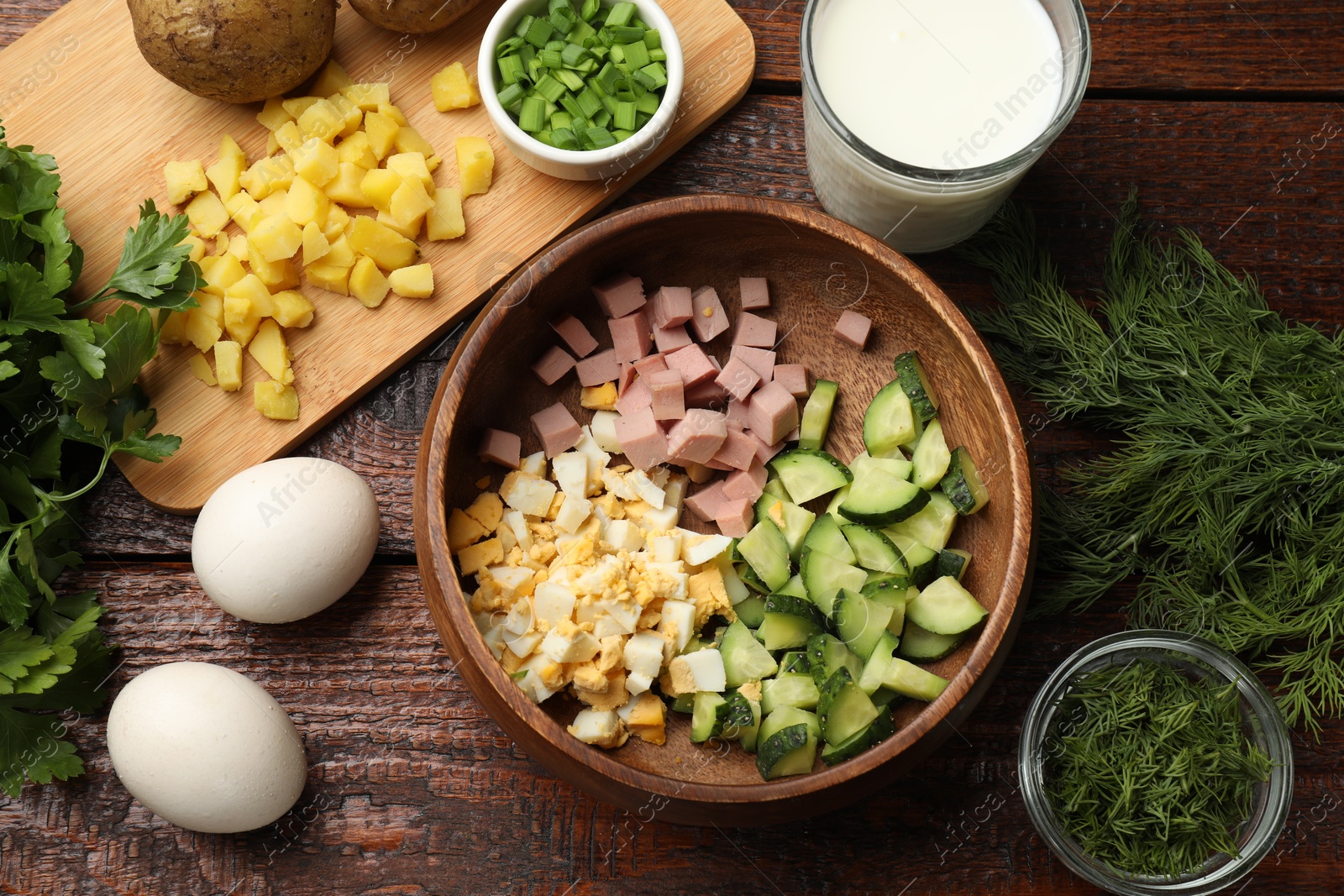 Photo of Different ingredients for okroshka soup on wooden table, flat lay