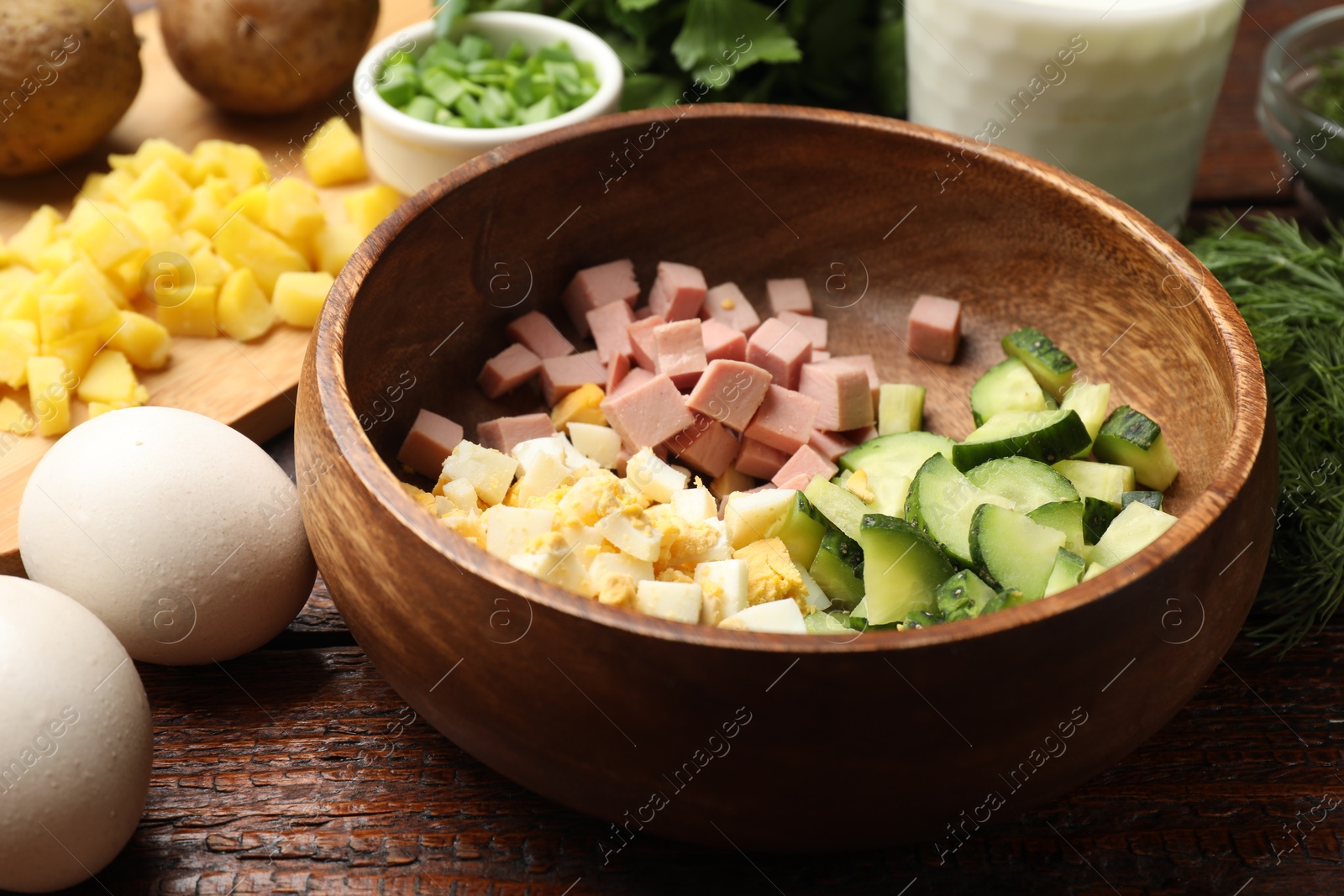 Photo of Different ingredients for okroshka soup on wooden table, closeup