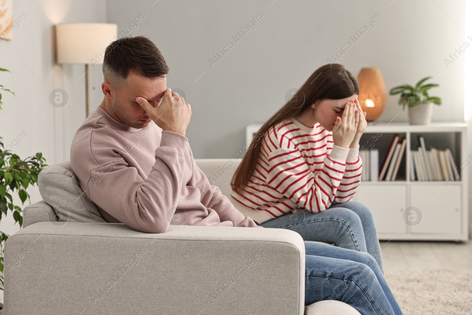 Photo of Offended couple ignoring each other at home