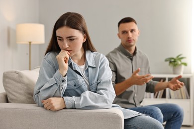 Photo of Upset woman ignoring her husband at home. Relationship problems