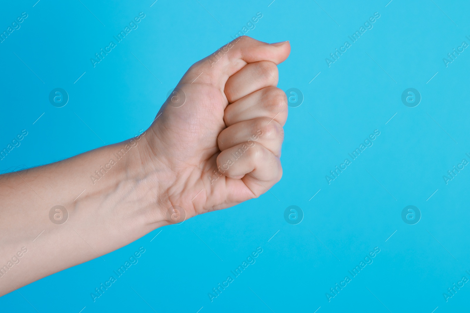 Photo of Woman with visible hand veins on light blue background, closeup