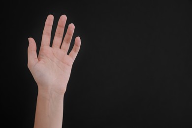 Photo of Woman with visible hand veins on black background, closeup. Space for text