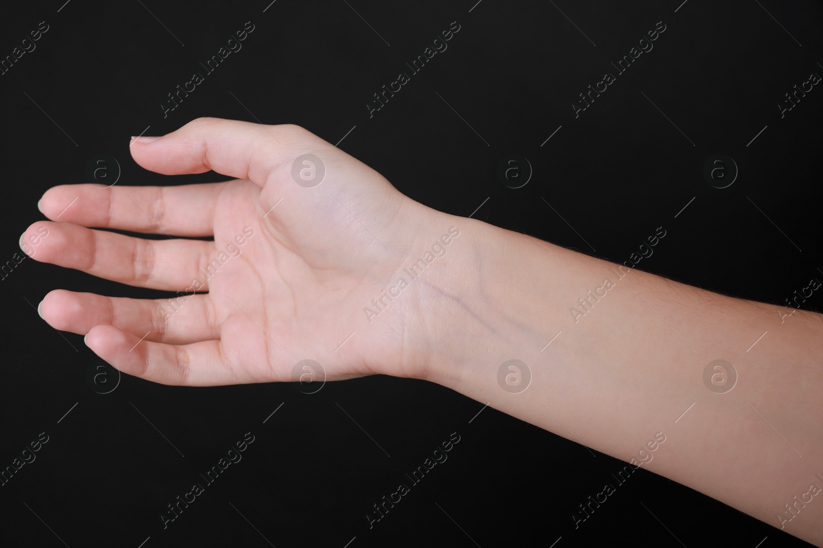 Photo of Woman with visible hand veins on black background, closeup