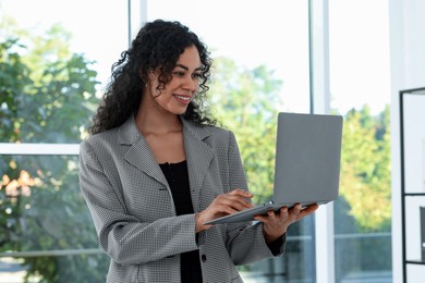 Photo of Portrait of young woman with laptop wearing stylish suit indoors