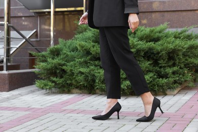 Photo of Young woman wearing stylish suit outdoors, closeup