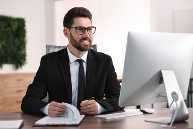 Man working with document at table in office