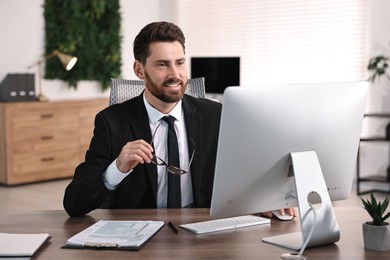 Photo of Man working on computer at table in office