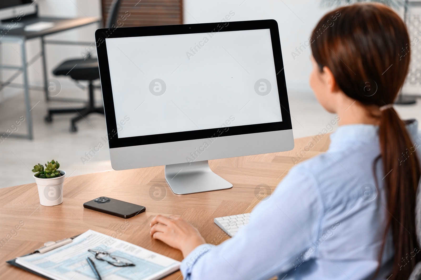 Photo of Woman working on computer at table in office