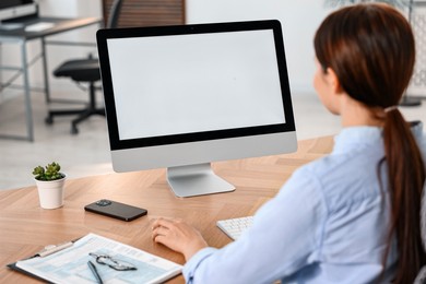 Photo of Woman working on computer at table in office