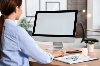 Photo of Woman working on computer at table in office