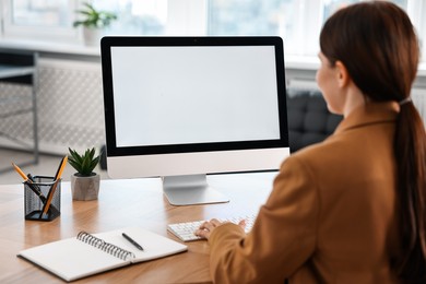 Photo of Woman working on computer at table in office